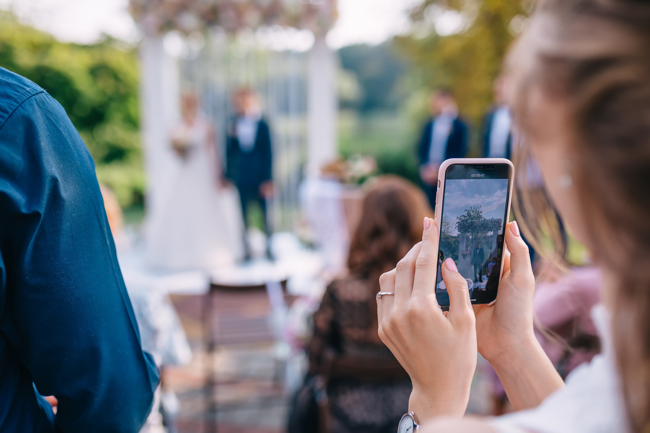 A guest films a wedding ceremony on a smartphone